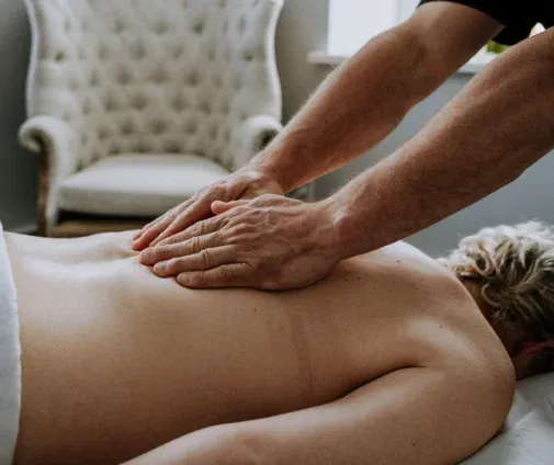 Hands applying pressure to the upper back during massage