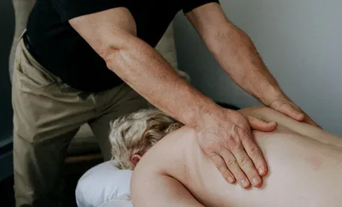 Mark Heilshorn applying focused pressure to a client’s lower back