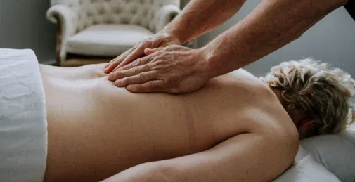 Hands applying pressure to the upper back during massage