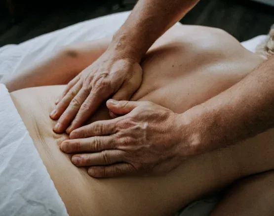 Hands applying gentle pressure to a client’s back