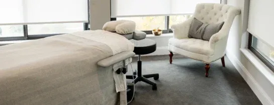 Massage table and seating beside the studio windows