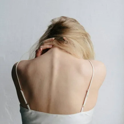 Woman holding her neck and shoulder
