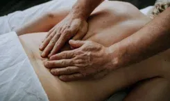Hands applying gentle pressure to a client’s back