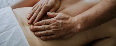 Hands applying gentle pressure to a client’s back