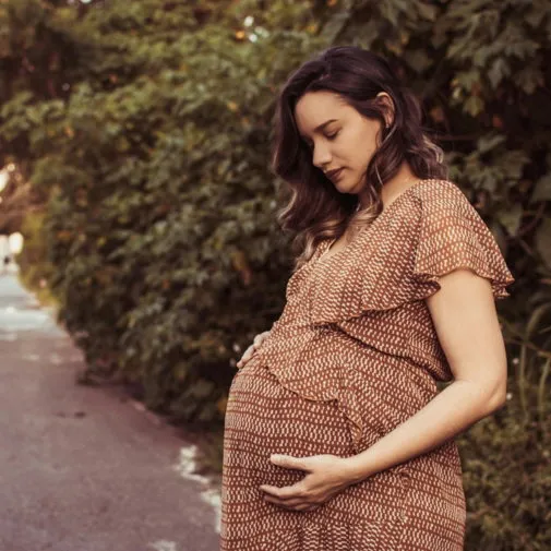 Expectant mother resting her hands on her belly